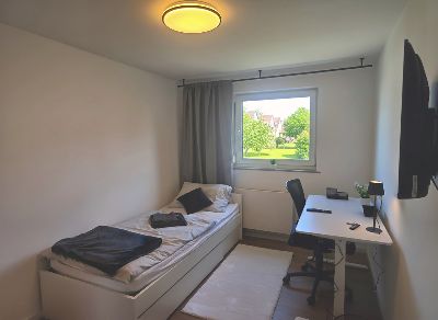 Zimmer 1: Bett und höhenverstellbarer Schreibtisch